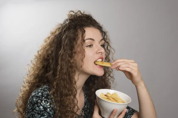 Портрет подростка, поедающего боулинг картофельных чипсов — стоковое фото