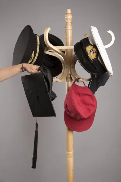 Hand putting hats onto a stand — Stock Photo, Image