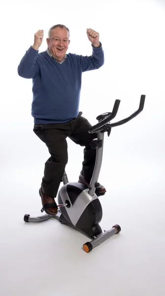 ELDERLY MAN ON AN EXERCISE BIKE — Stok Foto