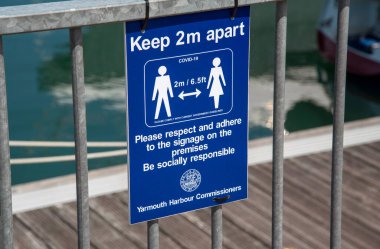 Freshwater Körfezi, Wight Adası, İngiltere. 2021 yılı. Covid-19 Ayrı tutun Yayalara 2 metre uzakta kalmaları için bir hükümet uyarısı imzalayın.