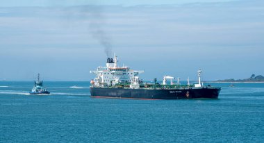 Solent, Southampton, İngiltere. 2021 yılı. Okyanus, İngiltere Southampton Water 'a dönerken büyük bir ham petrol tankerinin kıç tarafından çekiliyor.