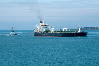 Solent, Southampton, İngiltere. 2021 yılı. Okyanus, İngiltere Southampton Water 'a dönerken büyük bir ham petrol tankerinin kıç tarafından çekiliyor.