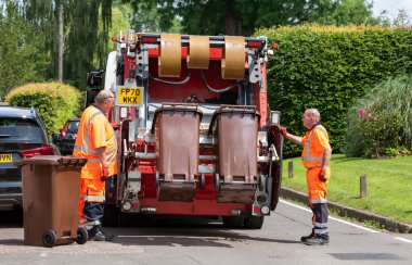 Hampshire, İngiltere, İngiltere. 2021 yılı. Konsey görevlileri, sıkıştırılmak, paketlenmek ve satılmak üzere kamyonla taşınan bahçe atıklarını topluyorlar..