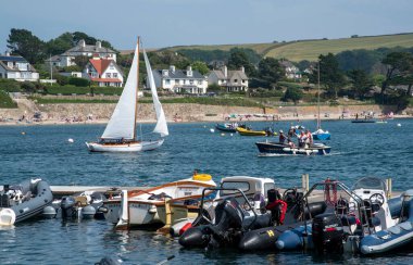 St Mawes, Cornwall, İngiltere. 2021 yılı. Yolcuları ve yelkenli teknesi olan bir liman taksisi ve bir tatil evi zemin zemin ve St Mawes, İngiltere 'de küçük bir plaj..