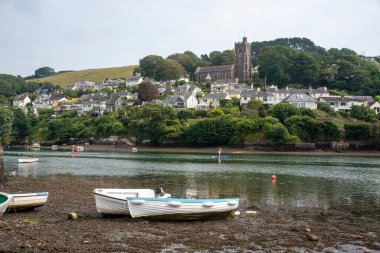Noss Mayo ve Newton Ferrers, Devon, İngiltere, İngiltere. 2021 yılı. Noss Mayo, Yealm Nehri 'nin karşısında Newton Ferrers' dan Güney Devon, İngiltere 'de çekici bir yerleşim yeri olarak görüldü. Tepedeki Aziz Peter Kilisesi 'ne doğru bakıyorum.