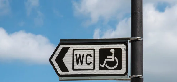 2021 다니는 사람들을 공개적 장애인 화장실을 가리키는 표지와 내림차순 — 스톡 사진