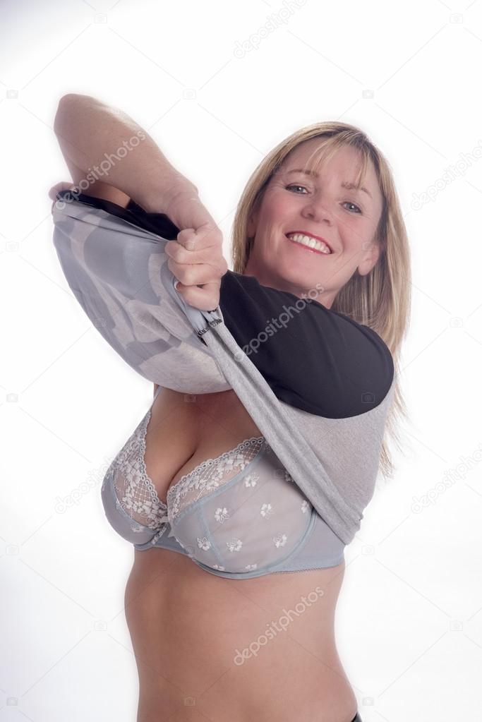 Woman removing her sweater to reveal her bra Stock Photo by