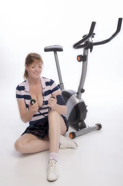Woman checking blood pressure after riding an exercise bike — Stock Photo, Image