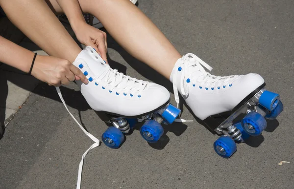 Menina amarrando laços em patins — Fotografia de Stock