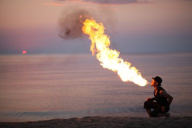 Amazing fire show in the evening on the beach clipart