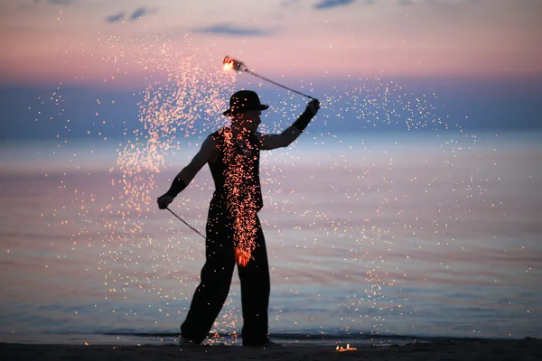 Удивительное огненное шоу вечером на пляже — стоковое фото