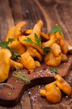 Fresh chanterelle mushrooms on a rustic table, close up clipart