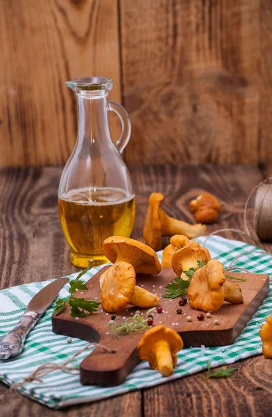 taze Cantharellus cibarius mantar bıçakla, rustik bir masaya yakın çekim