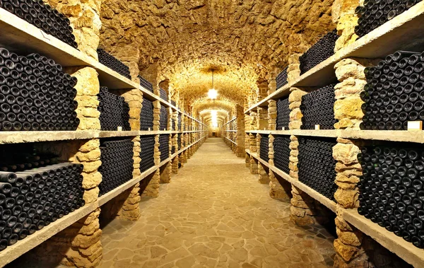 Стародавні пляшки вина в стародавньому підвалі — стокове фото
