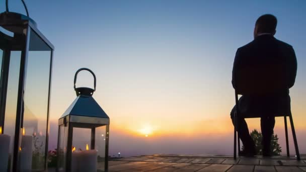 Бизнесмен смотрит на восход солнца на террасе Лицензионные Стоковые Видеоролики