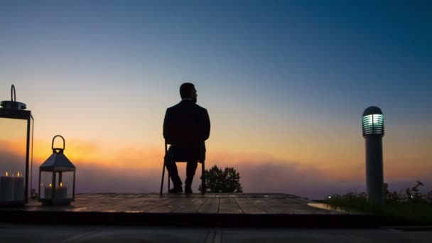 Бизнесмен смотрит на восход солнца на террасе Видеоклип