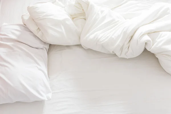 Vista dall'alto di un letto sfatto con cuscino, lenzuolo e coperta . — Foto Stock