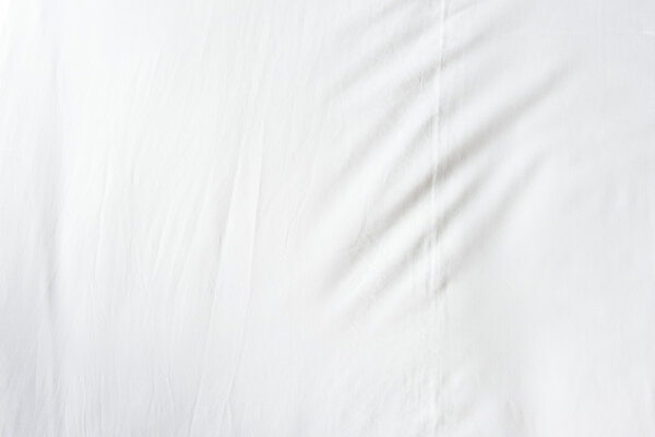 Top view of wrinkles on an unmade bed sheet after a long night sleep and waking up in the morning.