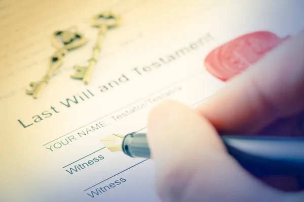 Man's right hand with fountain pen preparing to sign a form of last will and testament. — Stock Photo, Image