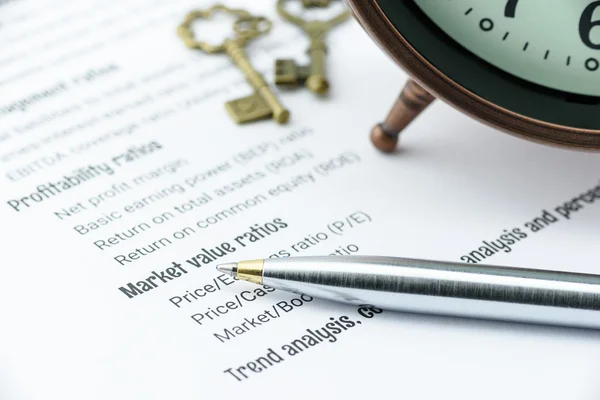Penna a sfera blu su una lista di controllo di analisi dei rapporti finanziari con un orologio antico e due chiavi in ottone vintage . — Foto Stock