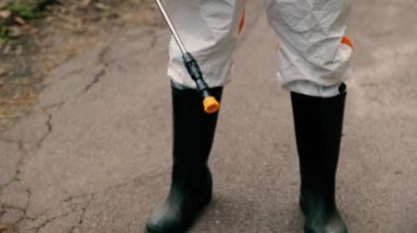 Üniformalı epidemiyoloji uzmanı parkta asfalt yolda duruyor.