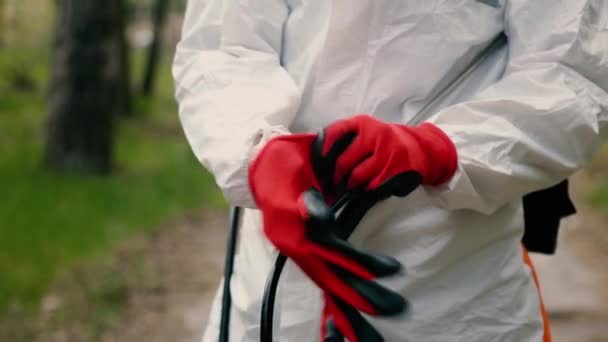 Epidemiolog i vit skyddsdräkt tar på sig röda handskar — Stockvideo
