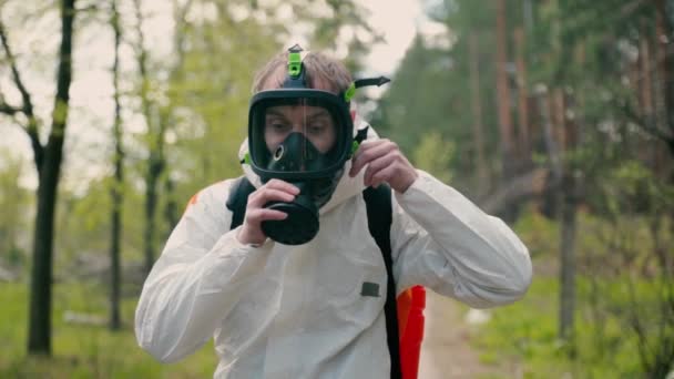 Reifer Desinfektionsdienst zieht Atemschutzmaske an — Stockvideo