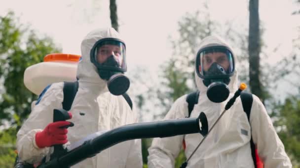 Epidemiologen in Ausrüstung posieren gegen verschwommenen Park — Stockvideo