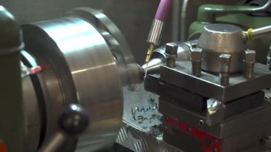 Deneyimli torna operatörü bir metal atölyesinde çalışıyor. Endüstriyel atmosfer, detaylara odaklanma ve metalik sesler belgesel tarzı bir hava yaratır.