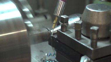Makinist torna tezgahı işletiyor, metal parçaları çeviriyor. Bir atölyede endüstriyel üretim ve hassas metal işleme süreci