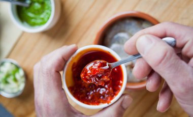 Baharatlı biberli kral karidesleri pişirmek - kırmızı sarımsak soslu marine edilmiş çiğ deniz ürünleri.