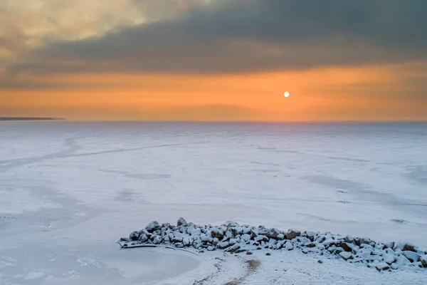 冬天的日落在一个结冰的海湾的海岸上 — 图库照片
