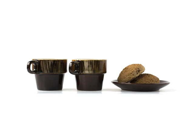 Dos tazas de cerámica con galletas en un plato aislado en blanco — Foto de Stock