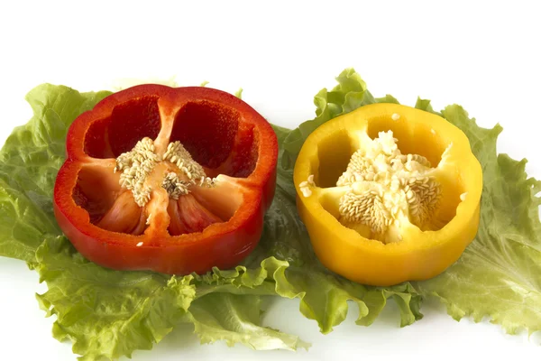 Geschnittene süße gelbe und rote Paprika auf Salatblättern Stockbild