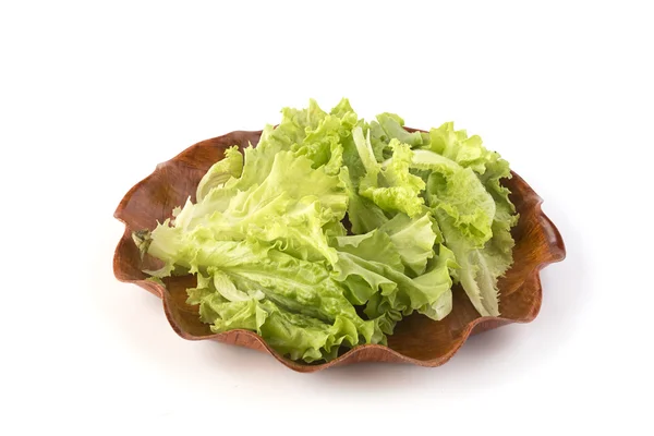 Foglie di insalata verde su un piatto di legno — Foto Stock