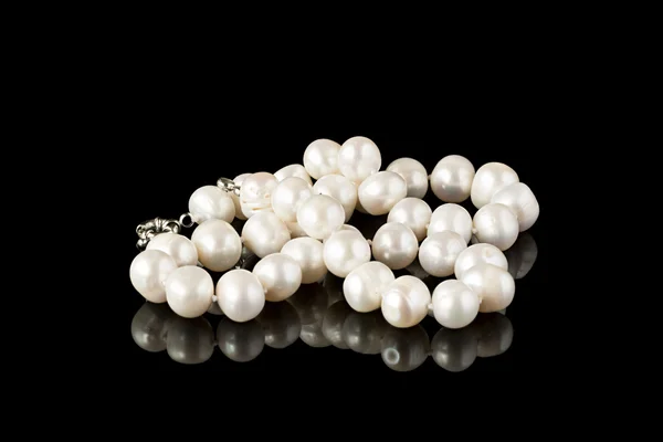 Collar de perlas en una superficie de espejo negro — Foto de Stock