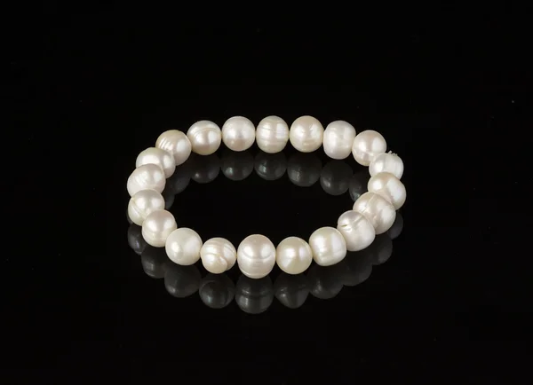 Pearl bracelet on a black mirror surface — Stock Photo, Image