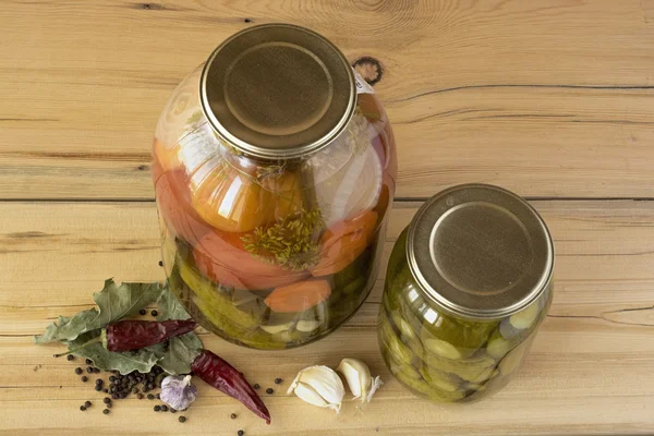 Een glazen potten met gezouten komkommers en tomaten en sommige specerijen — Stockfoto