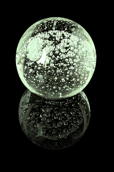 A glass ball with inner bubbles on a black mirror surface — Stock Photo, Image