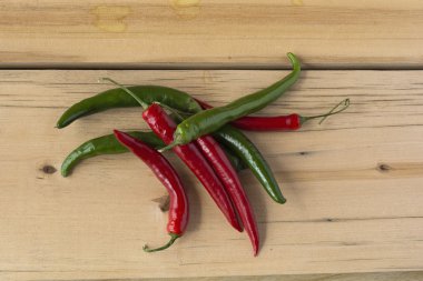 Sıcak ahşap bir masa üzerinde serin biber kırmızı ve yeşil. Üstten Görünüm