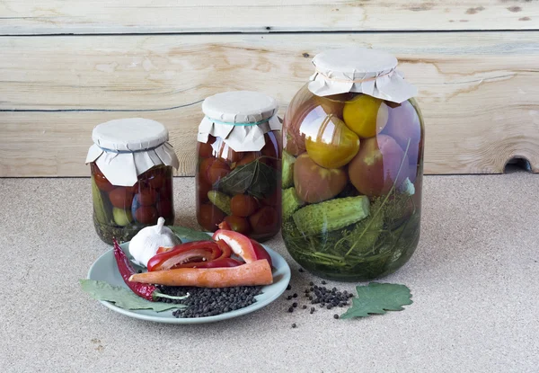 Gezouten tomaten en komkommers in een glas banken met kruiden op een — Stockfoto