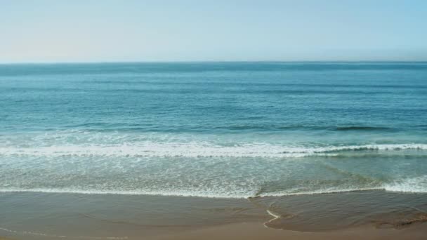 Мокрый пляжный песок, высохший после волн, вид красивых морских волн, ломающихся на песчаной береговой линии замедленного движения, глубокая синяя океанская вода и пенные волны Моррелло, 4k — стоковое видео