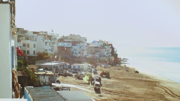 Pueblo de Taghazout 2019, cámara lenta, Hermoso pueblo de surf Taghazout Marruecos, pequeñas y acogedoras gaviotas de playa vuelan sobre, Océano Atlántico, 4k — Vídeos de Stock