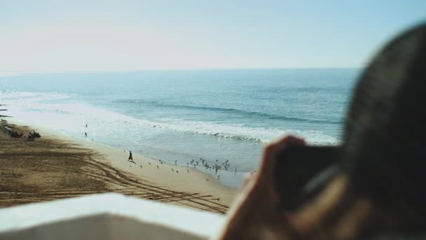 Close-up Man, view from back take shot how fisherman feeds the flock of gulls with the rest of the fish, sea waves breaking on sandy coast, slow motion, Morocco, 4k — Vídeo de stock