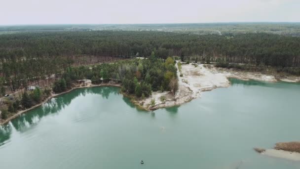 Légi kilátás a zöld erdő és a tó partján, homokos strand. Zöld erdő, tó nyár természetes táj fenyőerdővel. Természet Ukrajna, Levegő felett gyönyörű tó és zöld erdő — Stock videók