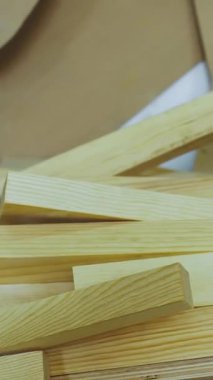 Dikey video. Ahşap, marangozluk için kereste ve endüstride mobilya üretimi. Tahtalar üst üste yığılmış. Kerestelerin el işi için üretimi ve tahtaları. Küçük bir atölye. Yüksek kalite 4k