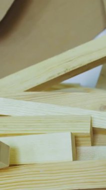 Dikey video. Ahşap yakın plan. Atölyedeki mobilya üretimi için kereste. Tahtalar üst üste yığılmış. Kerestelerin el işi için üretimi ve tahtaları. Ağır çekim. Yüksek kalite 4k görüntü