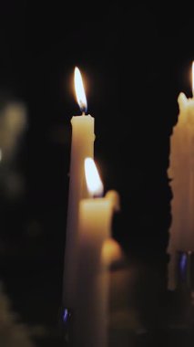 Dikey video. Masada mum yakmak. Mum ışığında akşam yemeği. Pastel renkli şölen masası dekoru. Düğün ya da doğum günü. Yüksek kalite 4k görüntü