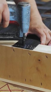 Dikey video. Mobilya fabrikasında kanepe yapan bir işçi. Pnömatik silahla çalışan bir işçi, ağır çekimde. Yüksek kalite 4k görüntü