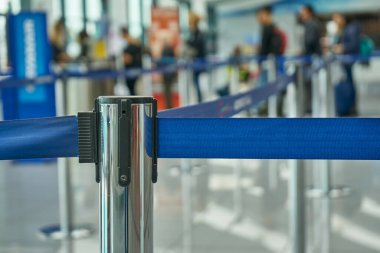 Geri çekilebilir kemerin eklentisi. Taşınabilir bant engeli. Çit Mavi Renk. Havaalanı Sahnesi Yolcuların biniş için beklediği